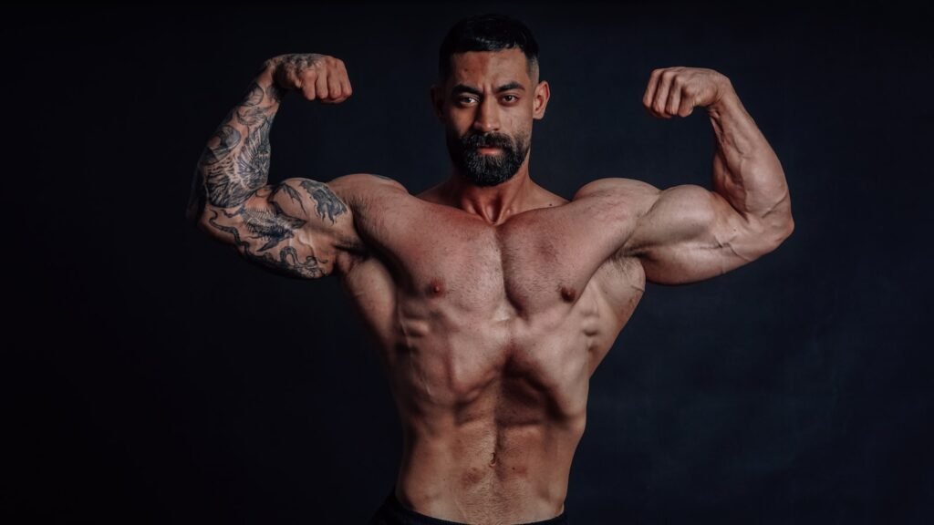 A muscular man flexes his biceps.