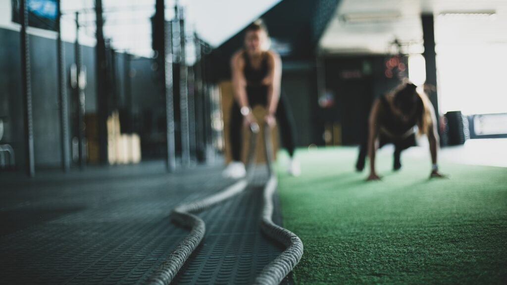 two person inside gym exercising with rope